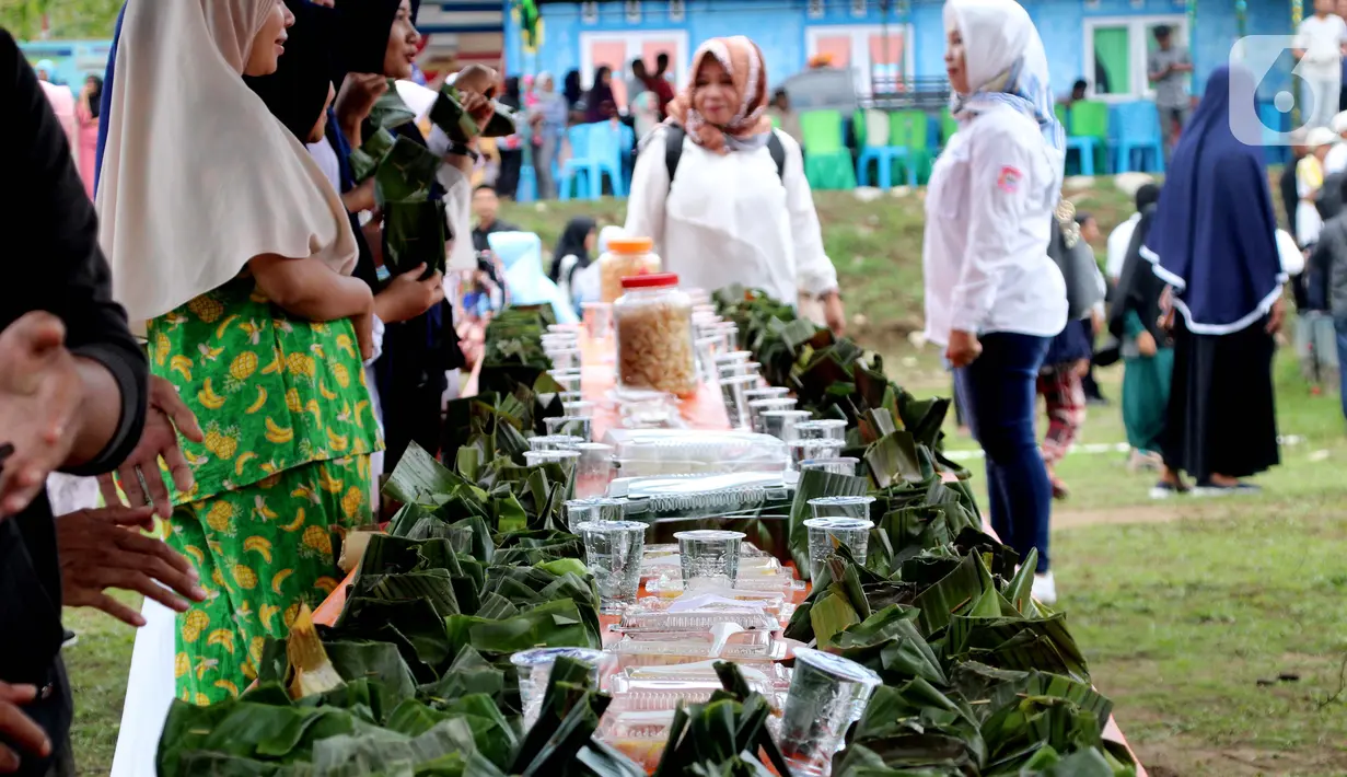 Warga melihat bungkus nasi kuning selama Gebyar Safar 1441 H di Desa Pangi, Kecamatan Suwawa Timur, Kabupaten Bone Bolango (Bonebol), Rabu (23/10/2019). Sebanyak 5.000 bungkus nasi kuning disajikan dalam perayaan yang turut dihadiri Bupati Bone Bolango, Hamim Pou, itu. (Liputan6.com/Arfandi Ibrahim)