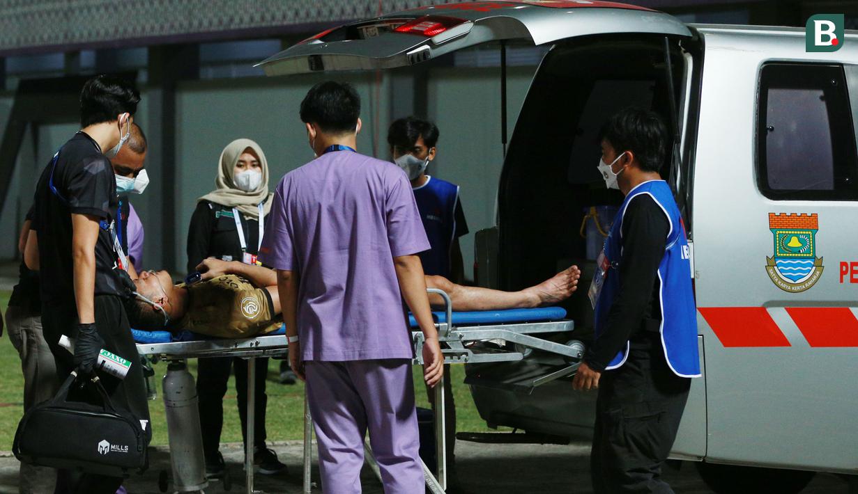 Setelah mendapatkan perawatan dari tim medis, akhirnya Wawan ditandu keluar lapangan dan dibawa ke Rumah Sakit terdekat menggunakan ambulance. (Bola.com/M Iqbal Ichsan)