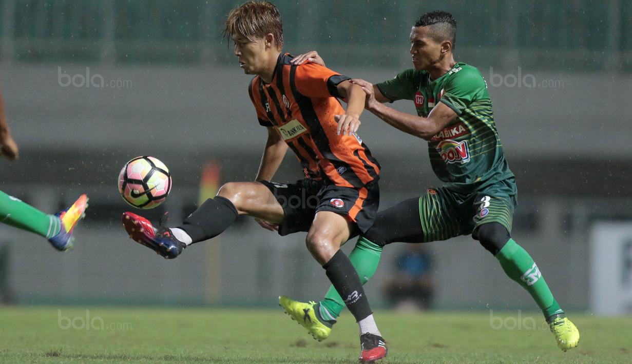 Pemain PS TNI, Abuh Lestaluhu (kanan) menahan laju membayangi gerakan pemain Perseru Serui, Karube Ryutaro pada lanjutan Liga 1 2017 di Stadion Pakansari, Bogor (07/10/2017). PS TNI menang 2-1. (Bola.com/Nicklas Hanoatubun)