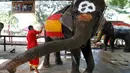Sebelum berlaga, para pawang membuat gambar bendera negara yang akan berlaga di Piala Dunia 2014 di tubuh gajah, (9/6/2014). (REUTERS/Chaiwat Subprasom)