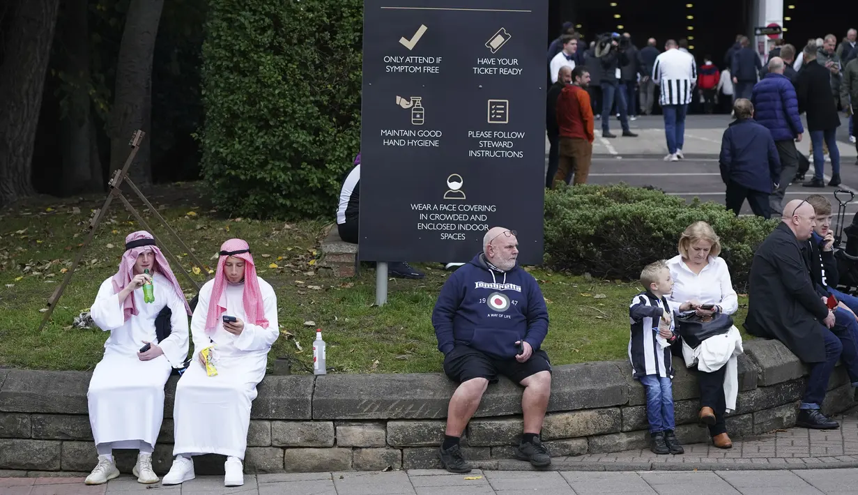 Penggemar Newcastle duduk di luar lapangan sebelum pertandingan sepak bola Liga Premier Inggris antara Newcastle dan Tottenham Hotspur di St. James' Park di Newcastle, Inggris, Minggu 17 Oktober 2021. (AP/Jon Super)