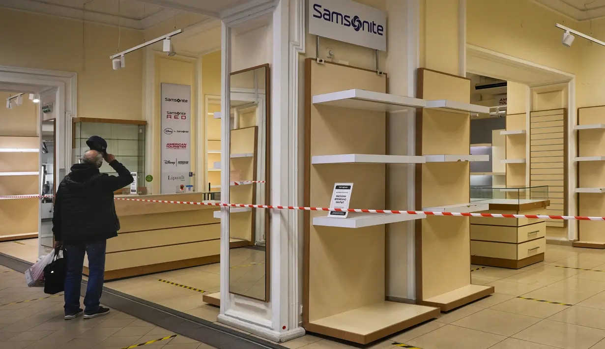 <p>Seorang pengunjung melihat "Samsonite" kosong, toko koper dan tas ditutup karena sanksi barat di sebuah toko di St. Petersburg, Rusia, Selasa, 31 Mei 2022. Banyak perusahaan Barat telah meninggalkan Rusia setelah dimulainya invasi Moskow ke Ukraina. (AP Photo/Dmitri Lovetsky)</p>