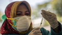 Seorang dokter bersiap untuk memberikan vaksin virus corona COVID-19 Sinovac di klinik vaksinasi massal darurat di lapangan sepak bola di Surabaya, Jawa Timur, Selasa (6/7/2021). Indonesia tengah memerangi gelombang infeksi baru yang belum pernah terjadi sebelumnya. (JUNI KRISWANTO/AFP)
