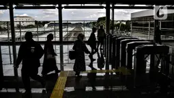 Penumpang kereta Commuter Line melintasi pintu akses yang kini berada di lantai atas Stasiun Jatinegara, Jakarta, Rabu (16/12/2020). Dirjen Perkeretaapian Kemenhub mengoperasikan kembali layanan di Stasiun Jatinegara yang kini memiliki 8 jalur dengan 4 peron.(merdeka.com/Iqbal S. Nugroho)