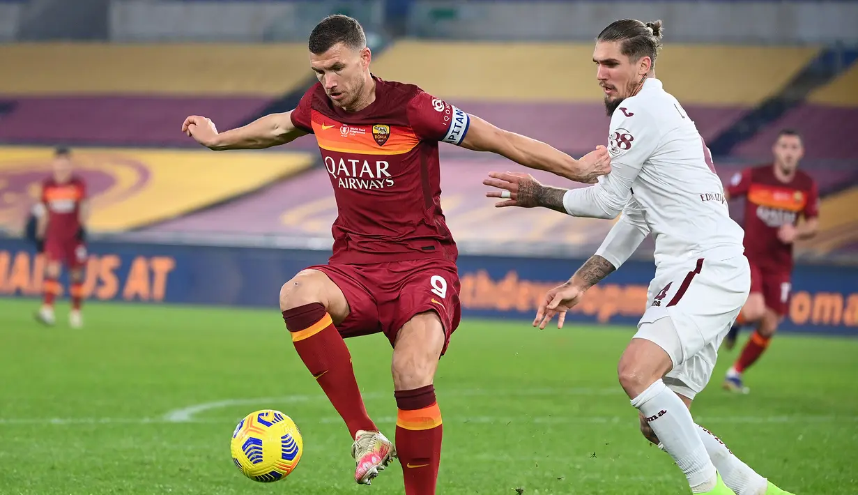 Penyerang AS Roma, Edin Dzeko, berebut bola dengan bek Torino, Lyanco Vojnovic, pada laga lanjutan Liga Italia di Stadion Olimpico, Jumat (18/12/2020) dini hari WIB. AS Roma menang 3-1 atas Torino. (AFP/Vincenzo Pinto)
