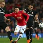 Pemain Manchester United Jesse Lingard berebut bola dengan pemain Sevilla Simon Kjaer dan Gabriel Mercado pada laga leg kedua 16 besar Liga Champions di Old Trafford, Selasa (13/3). Manchester United di luar prediksi takluk 1-2. (AP/Dave Thompson)