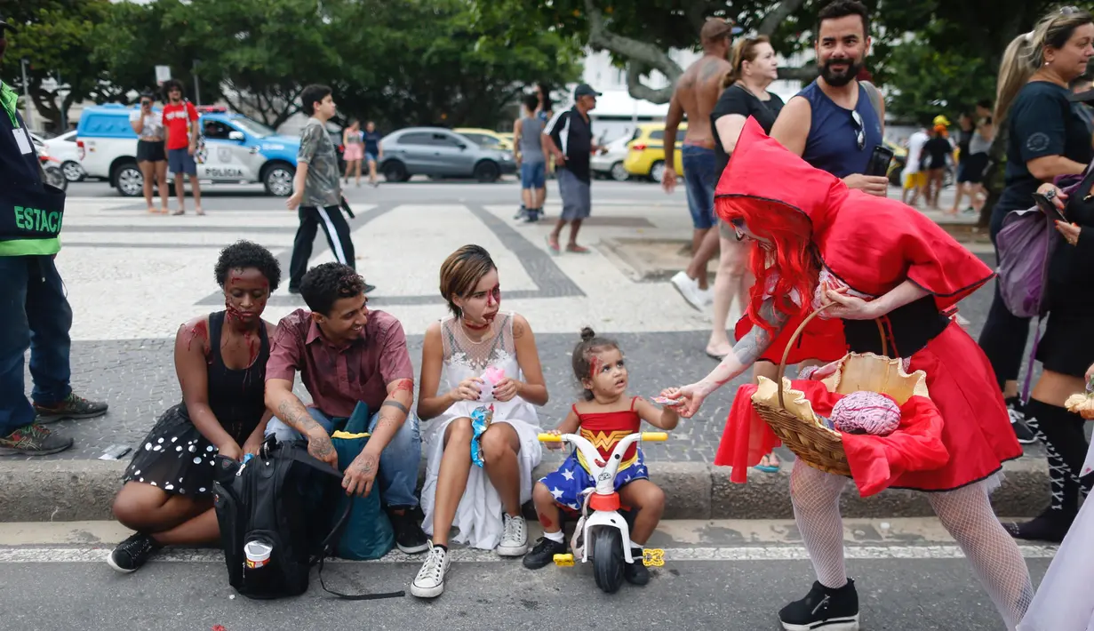 Pengunjung memakai kostum dan dandanan menyerupai zombie dalam acara Zombie Walk di pantai Copacabana, Rio de Janeiro, Brasil, Jumat (2/11). Ribuan orang ini beraksi sebagai Zombie untuk memeriahkan peringatan Hari Para Arwah. (Mauro PIMENTEL/AFP)
