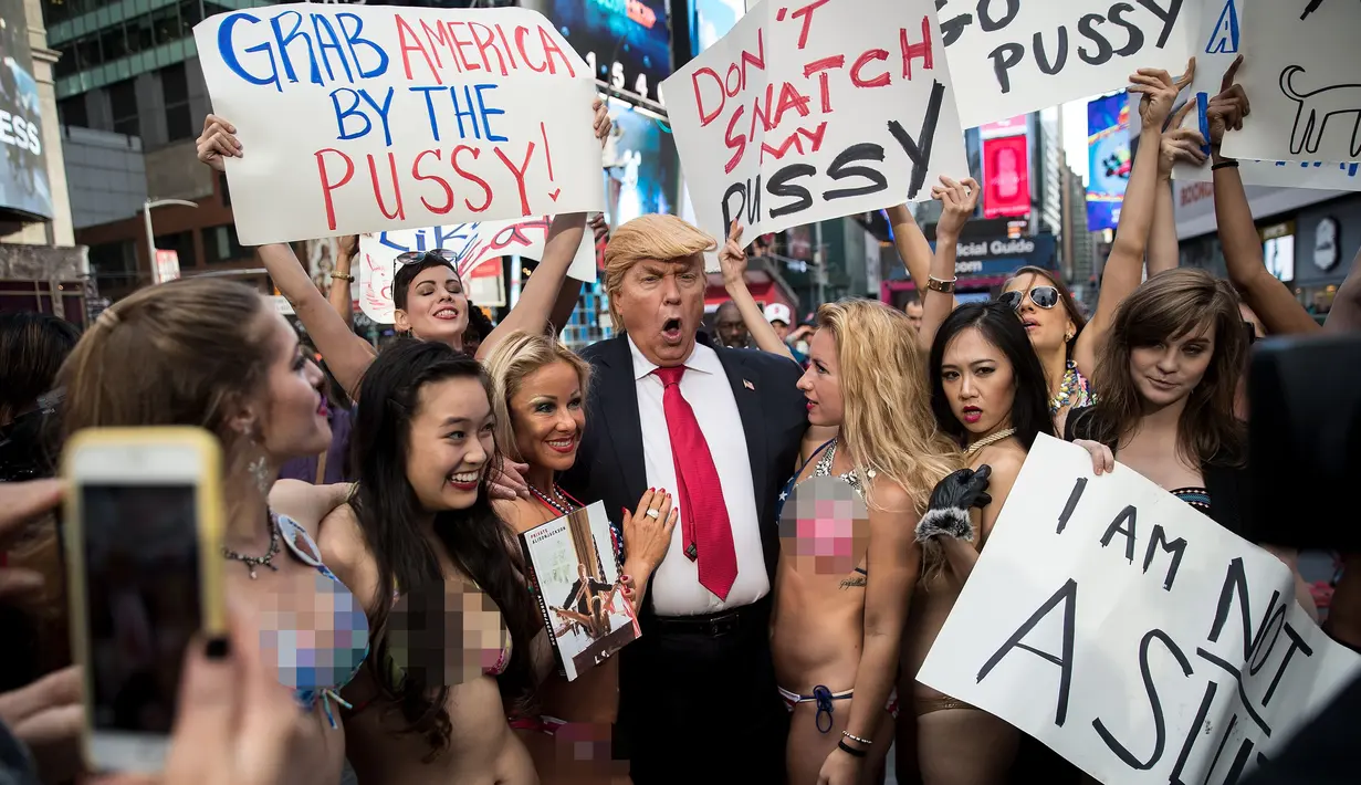 Sejumlah wanita seksi berbikini mengililingi seniman berpenampilan seperti Donald Trump saat unjuk rasa di depan Times Square, New York (25/10). Aksi ini dilakukan oleh seniman Alison Jackson. (AFP Photo/Drew Angerer/Getty Images)