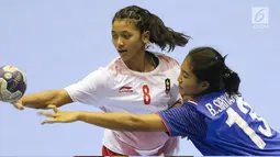 Pemain bola tangan putri Indonesia, M Shinta Hidayatuzzaroh (kiri) berebut bola dengan bek Thailand, Siriyaporn Boonnet pada babak penyisihan grup B Asian Games 2018 di Jakarta, Kamis (16/8). Indonesia kalah 16-34. (Liputan6.com/Helmi Fithriansyah)