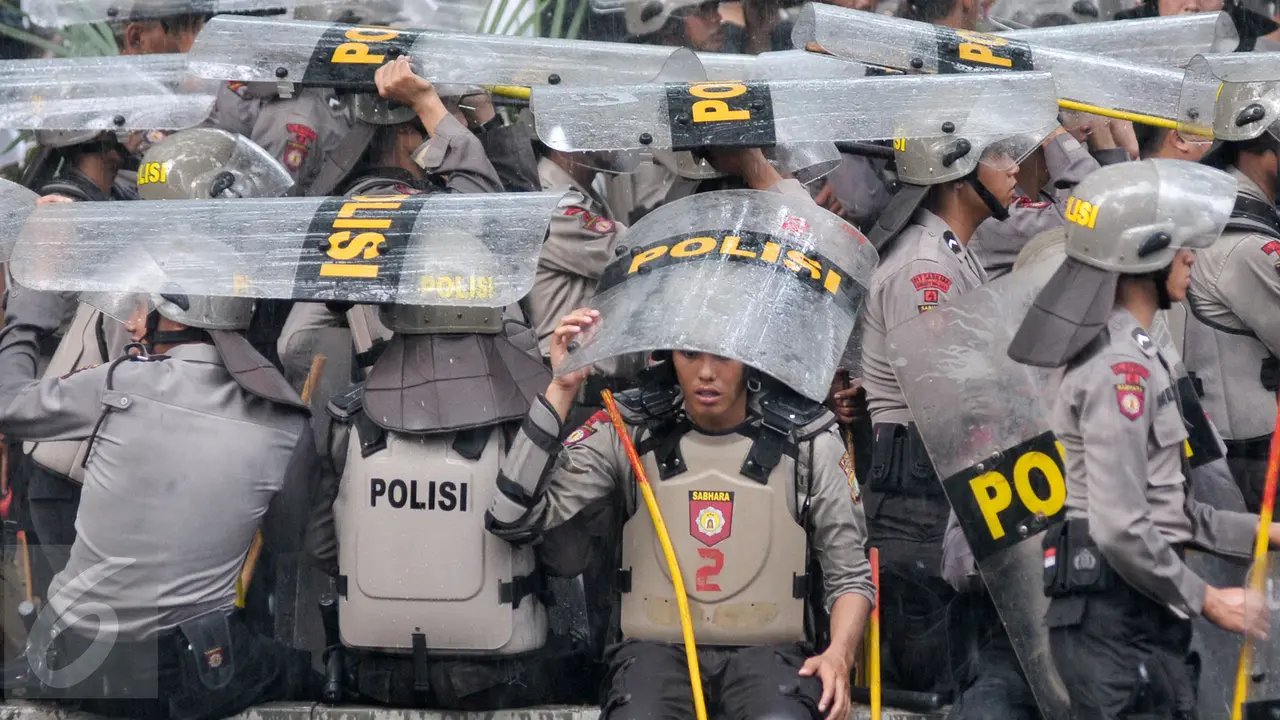 Jaga Aksi Hari Buruh Polisi Berlindung dengan Tameng Saat Hujan