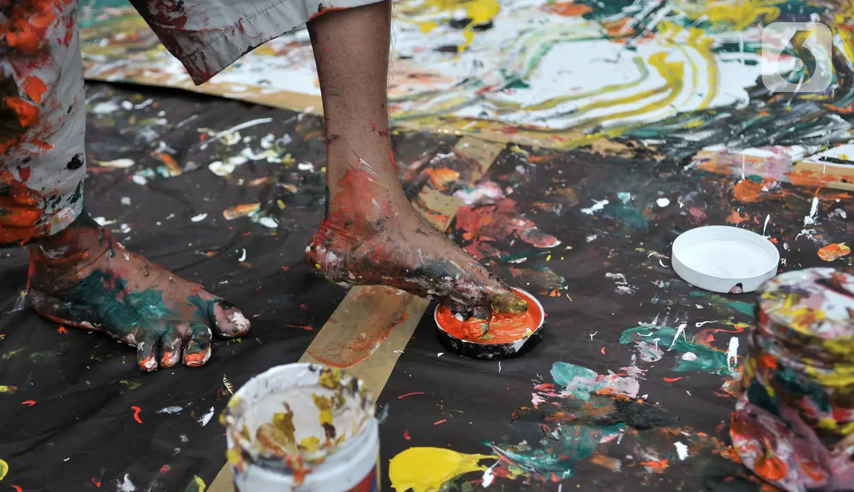 Sadikin Pard (53) membuat karya lukisan dengan kedua kakinya saat Indonesian Art Festival di Museum Nasional, Jakarta, Minggu (10/11/2019). Sadikin kini tergabung dalam Bengkel Pelukis Militan Indonesia, kelompok penggelar Indonesian Art Festival. (merdeka.com/Iqbal S. Nugroho)