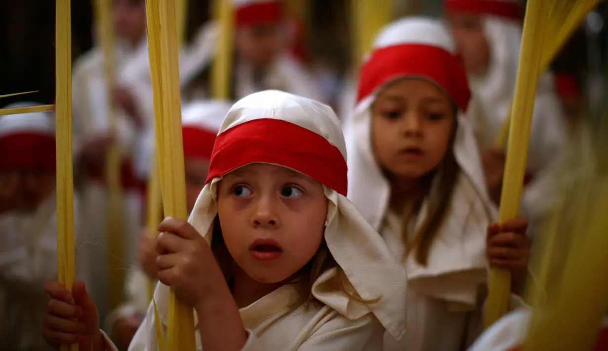 Anak-anak dari persaudaraan "La Borriquita" mengikuti pengakuan dosa dalam acara prosesi Pekan Suci di Cordoba, Spanyol (9/4). (AP Photo / Manu Fernandez)