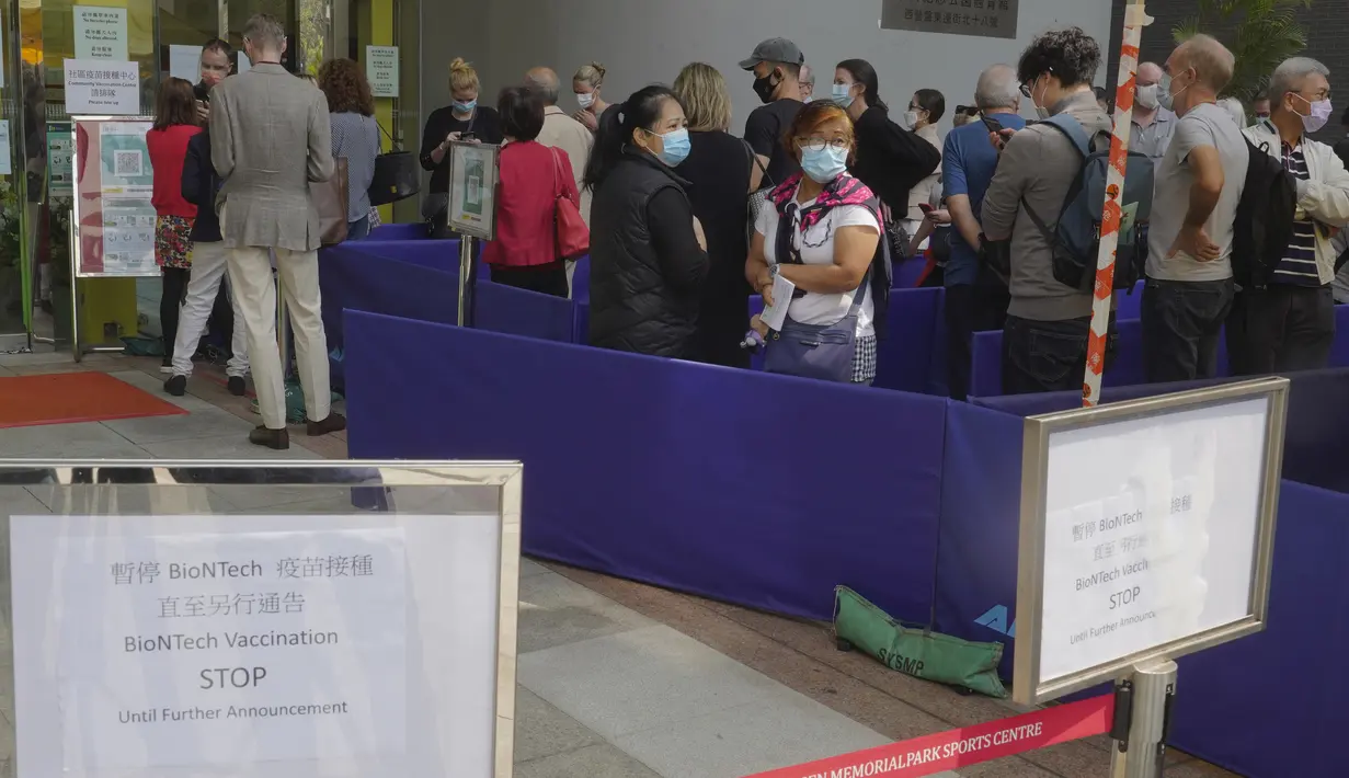 Orang-orang mengantre di luar pusat vaksinasi untuk BioNTech di Hong Kong pada Rabu (24/3/2021). Hong Kong untuk sementara menangguhkan penggunaan vaksinasi corona Covid-19 Pfizer/BioNTech karena laporan kerusakan pada pengemasan botol vaksin. (AP Photo/Vincent Yu)