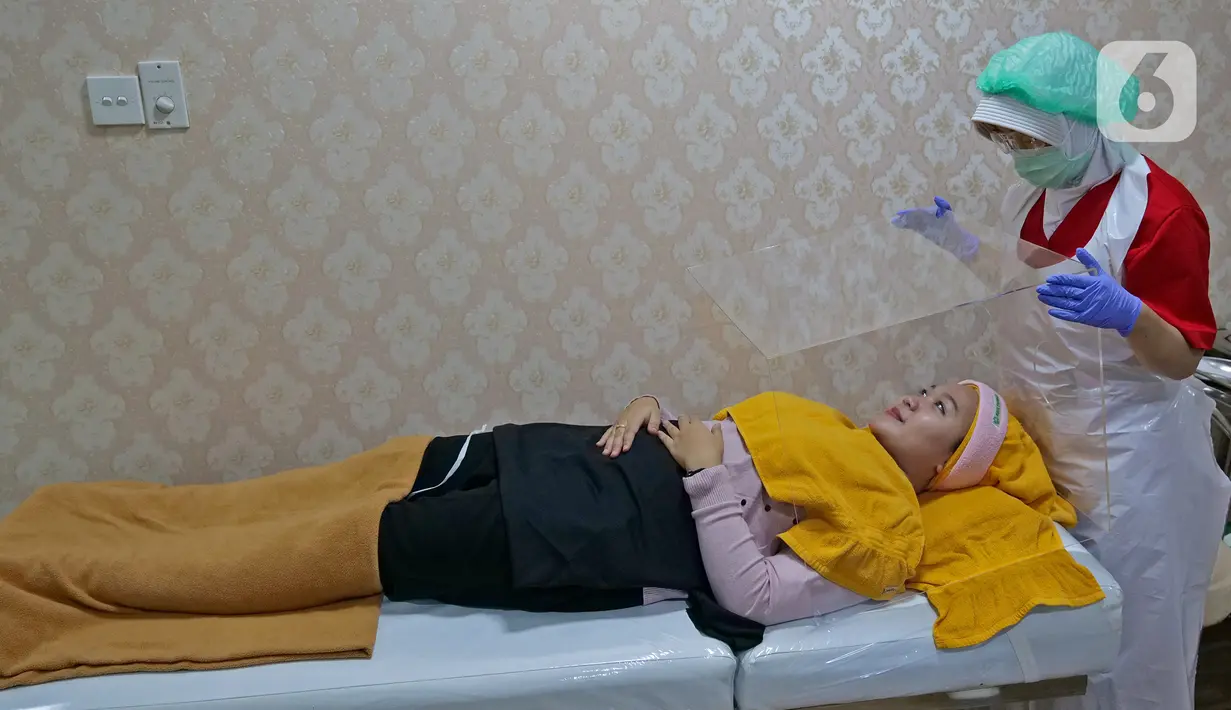 Perawat sedang menaruh Kotak Akrilik saat melakukan perawatan di Emerald Health and Beauty by RSIA Tambak, Jakarta, Jumat (19/06/2020). Perawatan wajah dengan protokol kesehatan tetap menjadi prioritas klinik kecantikan di era new normal saat pandemi COVID-19. (Liputan6.com/Herman Zakharia)