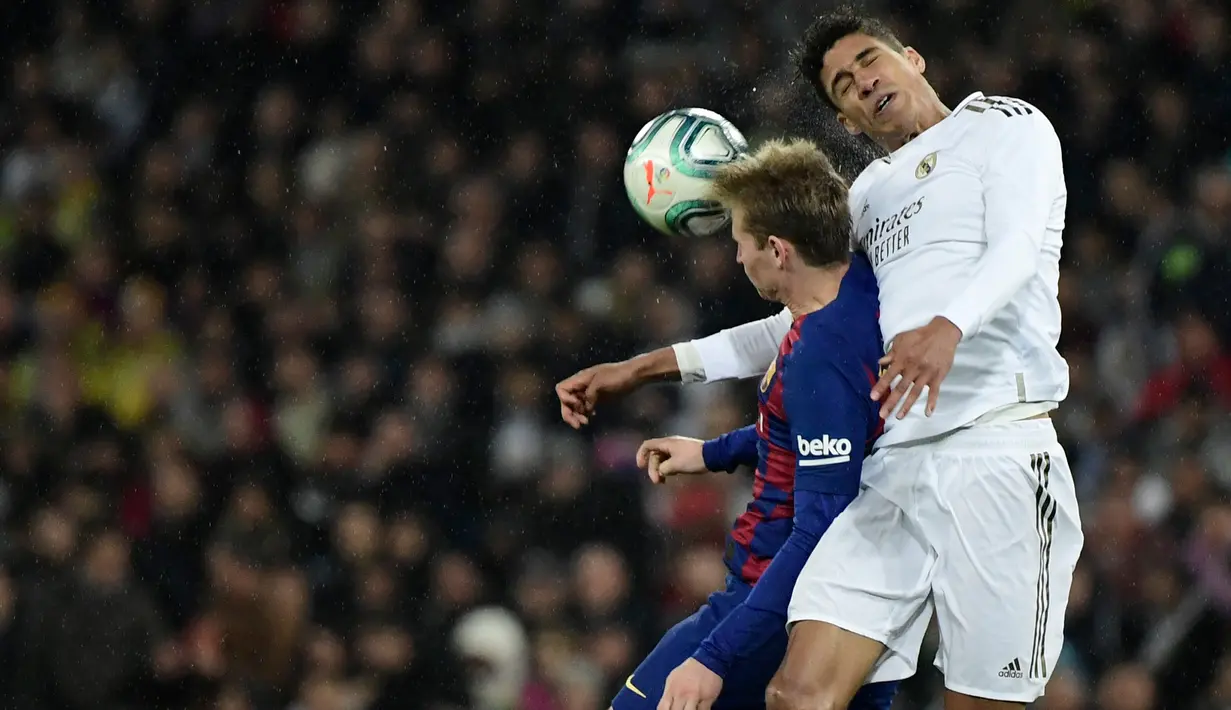 Bek Real Madrid, Raphael Varane (kanan) berebut bola dengan gelandang Barcelona, Frenkie De Jong pada lanjutan pertandingan La Liga di Santiago Bernabeu, Minggu (2/3/2020).  Real Madrid membungkam Barcelona 2-0 dan merebut puncak klasemen dari Barcelona. (JAVIER SORIANO/AFP)