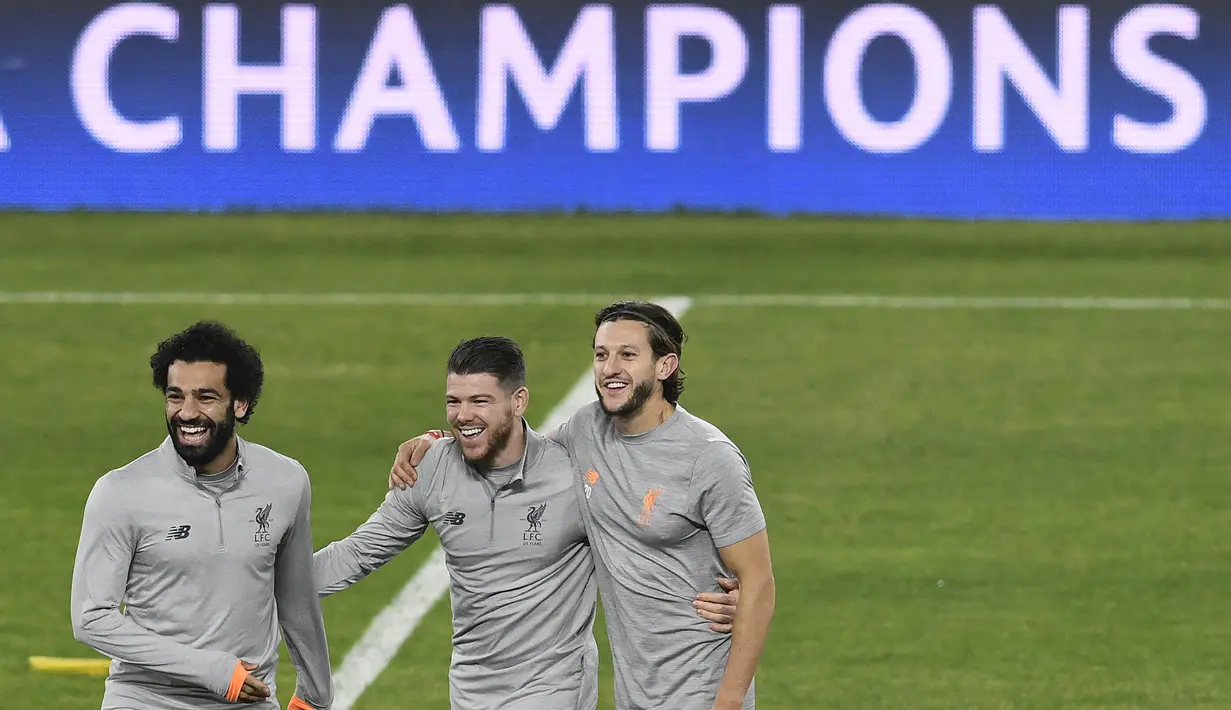 Pemain Liverpool, Mohamed Salah, Alberto Moreno dan Adam Lallana, tertawa saat sesi latihan jelang laga Liga Champions di Stadion Ramon Sanchez Pizjuan, Senin (20/17/2018). Liverpool akan berhadapan dengan Sevilla.  (AFP/Cristina Quicler)