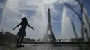Seorang gadis muda mendinginkan diri di dekat air mancur Trocadero, di tengah suhu tinggi di Paris, Kamis (16/6/2022). Prancis akan mengalami suhu yang memecahkan rekor mendekati 40 derajat Celcius pada Juni, karena gelombang panas dini yang diperkirakan akan melanda sebagian besar negara itu.
(JULIEN DE ROSA / AFP)