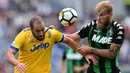 Duel pemain Juventus, Gonzalo Higuain (kiri) dengan pemain Sassuolo, Timo Letschert pada lanjutan Serie A di  Stadio Citta del Tricolore, Reggio Emilia, Italia (17/9/2017). Juventus menang 3-1. (AFP/Marco Bertorello)