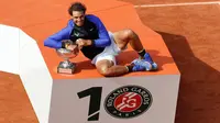 Petenis Rafael Nadal berpose dengan trofinya usai mengalahkan Stan Wawrinka pada final Prancis Terbuka di Roland Garros, Minggu (11/6). Atas kemenangan ini, Nadal sukses meraih gelar La Decima alias ke-10 di Prancis Open 2017. (AP Photo/Petr David Josek)