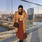 Cocok untuk OOTD musim dingin, kombinasikan long coat warna cokelat dengan rok plisket warna bata, kece! (Instagram/ayshaharun).