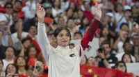 Pebulu tangkis Indonesia, Gregoria Mariska Tunjung memberi aplaus kepada penonton dari atas podium untuk menerima pengalungan medali perunggu nomor tunggal putri cabor bulu tangkis Olimpiade Paris 2024 saat upacara penyerahan medali di Porte de La Chapelle Arena, Paris, Senin (5/8/2024). (AP Photo/Kin Cheung)