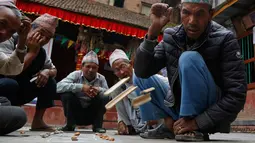 Lansia Nepal melempar bambu saat memainkan permainan tradisional Kashi Pyachha di Bhaktapur, Nepal (30/5). Permainan ini hampir hampir punah dan hanya populer di kalangan generasi yang lebih tua di Nepal. (AP/Niranjan Shrestha)