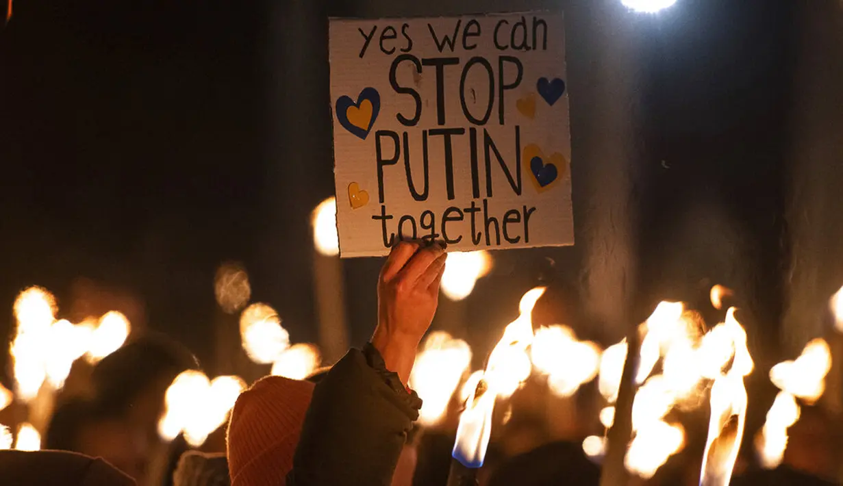 Seorang wanita memegang spanduk saat demonstrasi untuk Ukraina yang diselenggarakan oleh Greenpeace di Heroes Square, Budapest, Hungaria, 9 Maret 2022. Invasi Rusia ke Ukraina telah memicu migrasi massal terbesar di Eropa dalam beberapa dekade. (AP Photo/Anna Szilagyi)