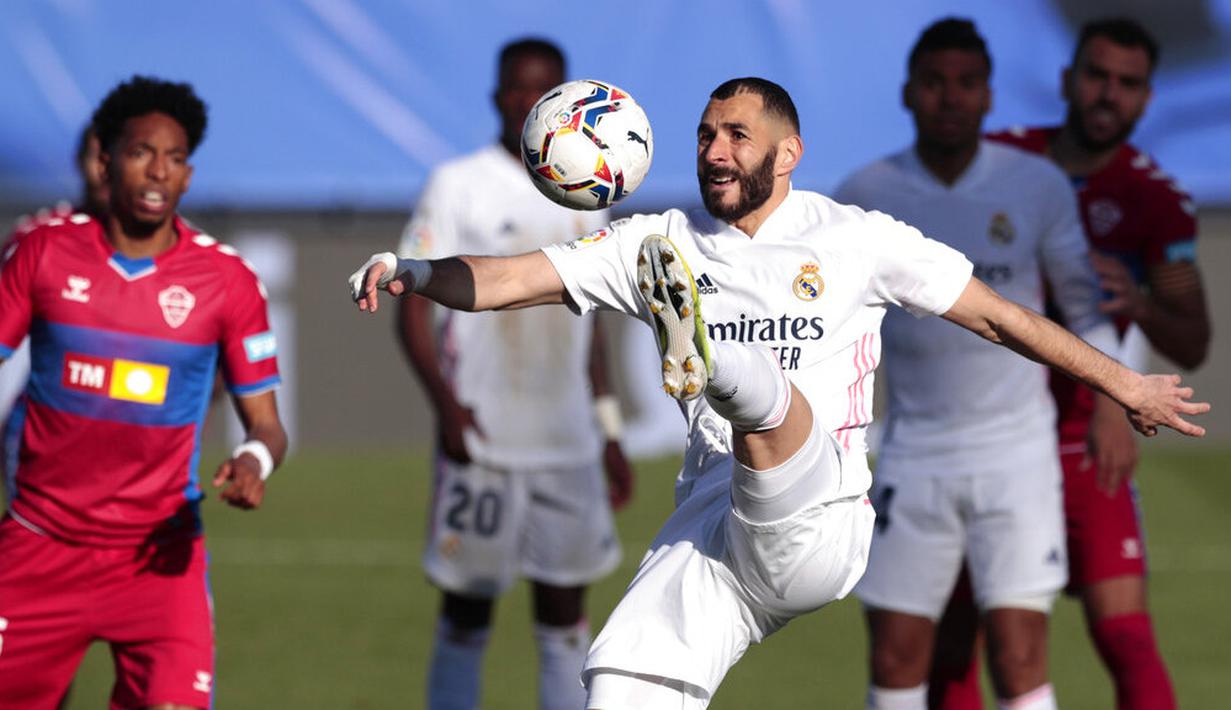 Striker Real Madrid, Karim Benzema, mengontrol bola saat melawan Elche pada laga Liga Spanyol di Stadion Alfredo di Stefano, Sabtu (13/3/2021). Real Madrid menang dengan skor 2-1. (AP/Bernat Armangue)