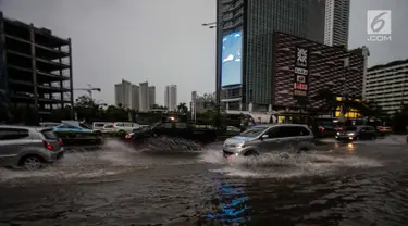 Kendaraan menerobos genangan air di kawasan MH Thamrin, Jakarta, Senin (11/12). Hujan lebat yang mengguyur wilayah Jakarta dan sekitarnya mengakibatkan air setinggi 15 cm menutupi sebagian badan jalan di kawasan tersebut. (Liputan6.com/Faizal Fanani)