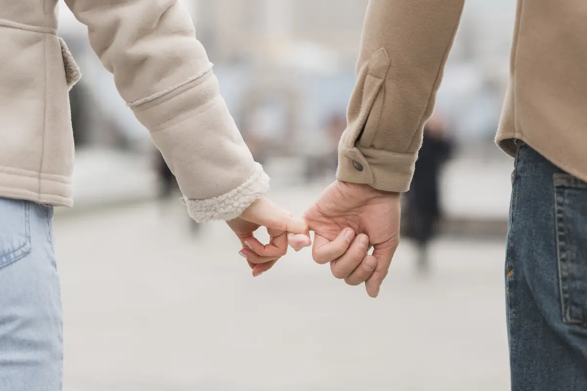 Sepasang kekasih saling memegang jari telunjuk satu sama lain sambil berjalan (Foto Dok: Freepik/freepik)
