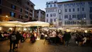 Pengunjung berbincang sambil menikmati minuman di di sebuah kafe menyusul pembatasan COVID-19 yang mulai dilonggarkan di Roma, Italia, Sabtu (6/2/2021). Pariwisata adalah sumber ekonomi Roma dan banyak orang berharap pelonggaran pembatasan jadi secercah harapan. (Cecilia Fabiano/LaPresse via AP)