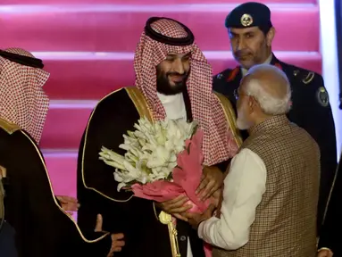 PM India, Narendra Modi memberikan bunga saat menyambut Putra Mahkota Arab Saudi Pangeran Mohammed bin Salman di bandara New Delhi, Selasa (19/2). Modi memutuskan  melanggar protokoler untuk secara pribadi menyambut Putra Mahkota Saudi. (AP/Manish Swarup)