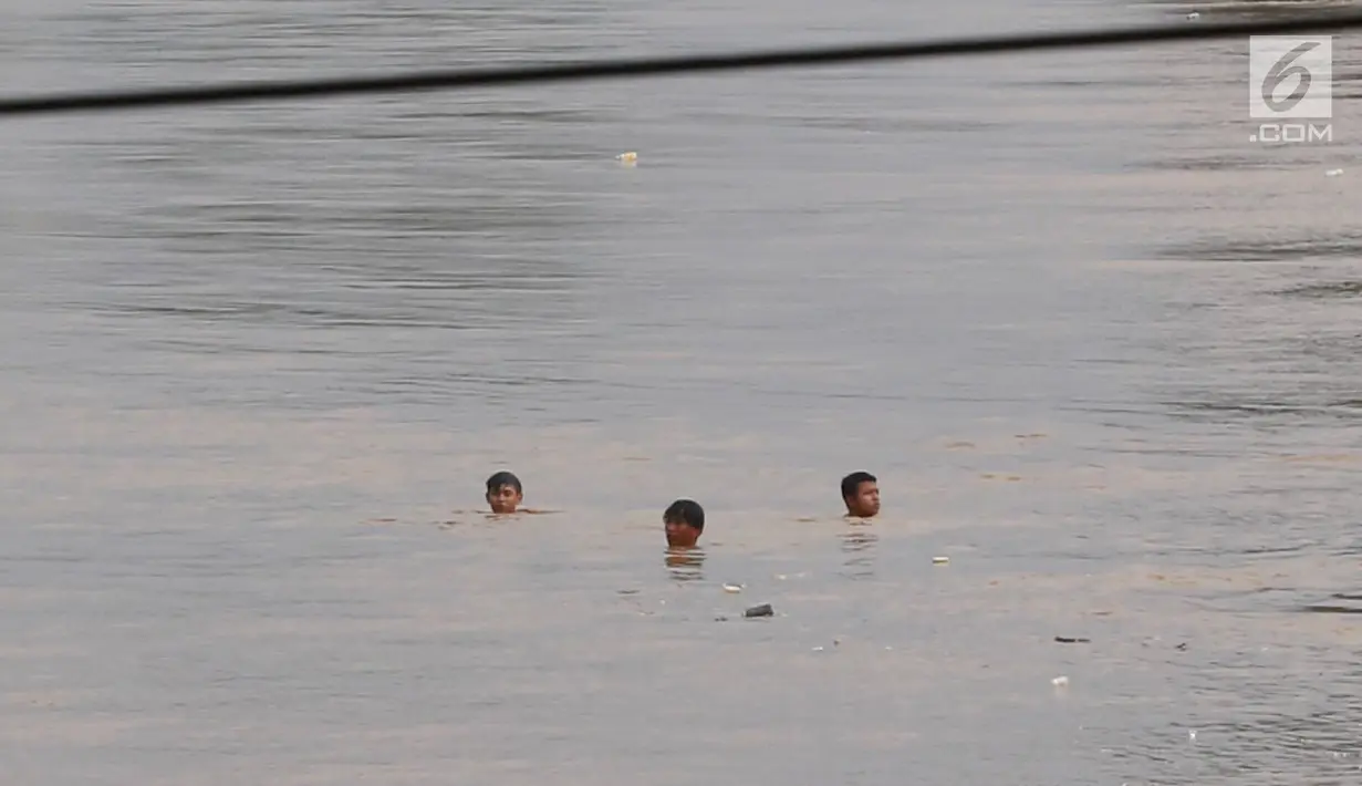 Anak-anak berenang di Sungai Ciliwung yang meluap di kawasan Rawajati, Jakarta, Jumat (26/4). Tingginya volume debit air yang berasal dari Bogor tidak menyurutkan niat anak-anak itu untuk tetap berenang, meskipun berbahaya bagi keselamatan. (Liputan6.com/Immanuel Antonius)