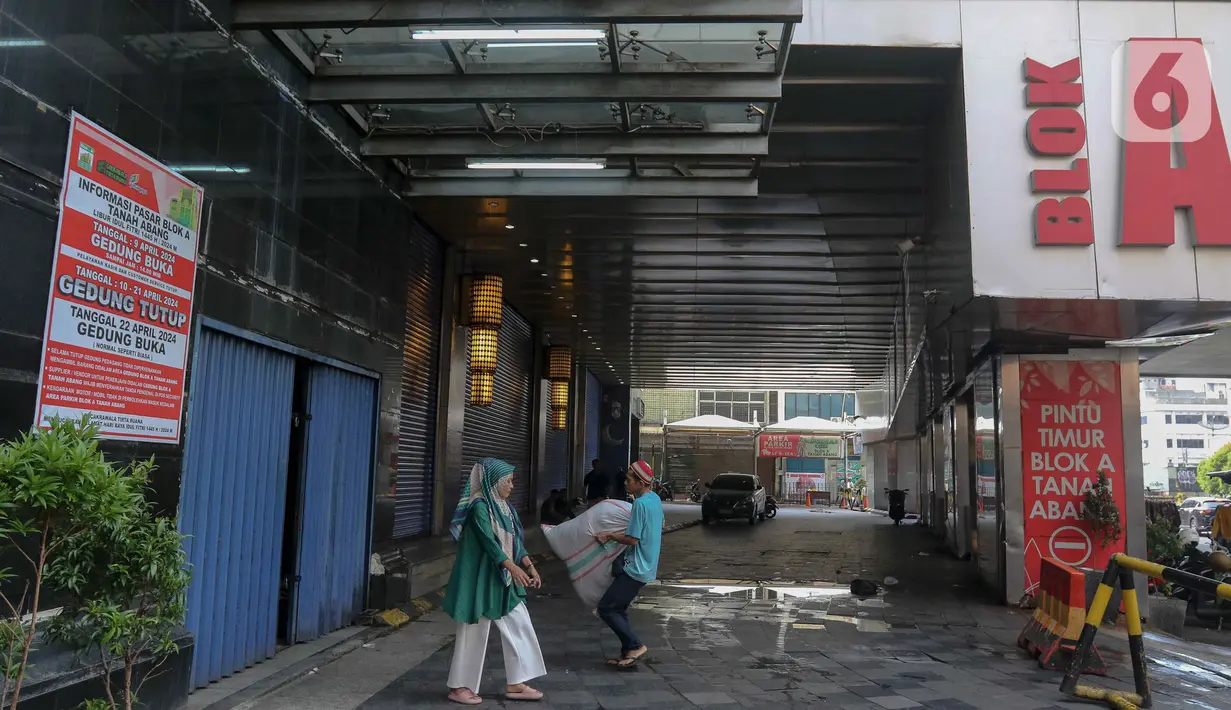 Warga melintas di depan Pasar Tanah Abang Blok A yang tutup di Jakarta, Jumat (12/4/2024). (Liputan6.com/Herman Zakharia)