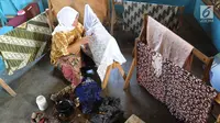 Seorang ibu membuat batik tulis di Kampung Batik Puswasedar kawasan Geopark Ciletuh, Sukabumi, Jawa Barat, Sabtu (22/9). Lebih dari 50 perempuan menekuni pembuatan batik tulis maupun cetak. (Merdeka.com/Arie Basuki)