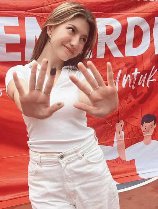 Cassandra Lee tampil kasual mengenakan kaus polo dan celana panjang serba warna putih. [@cassandraslee]