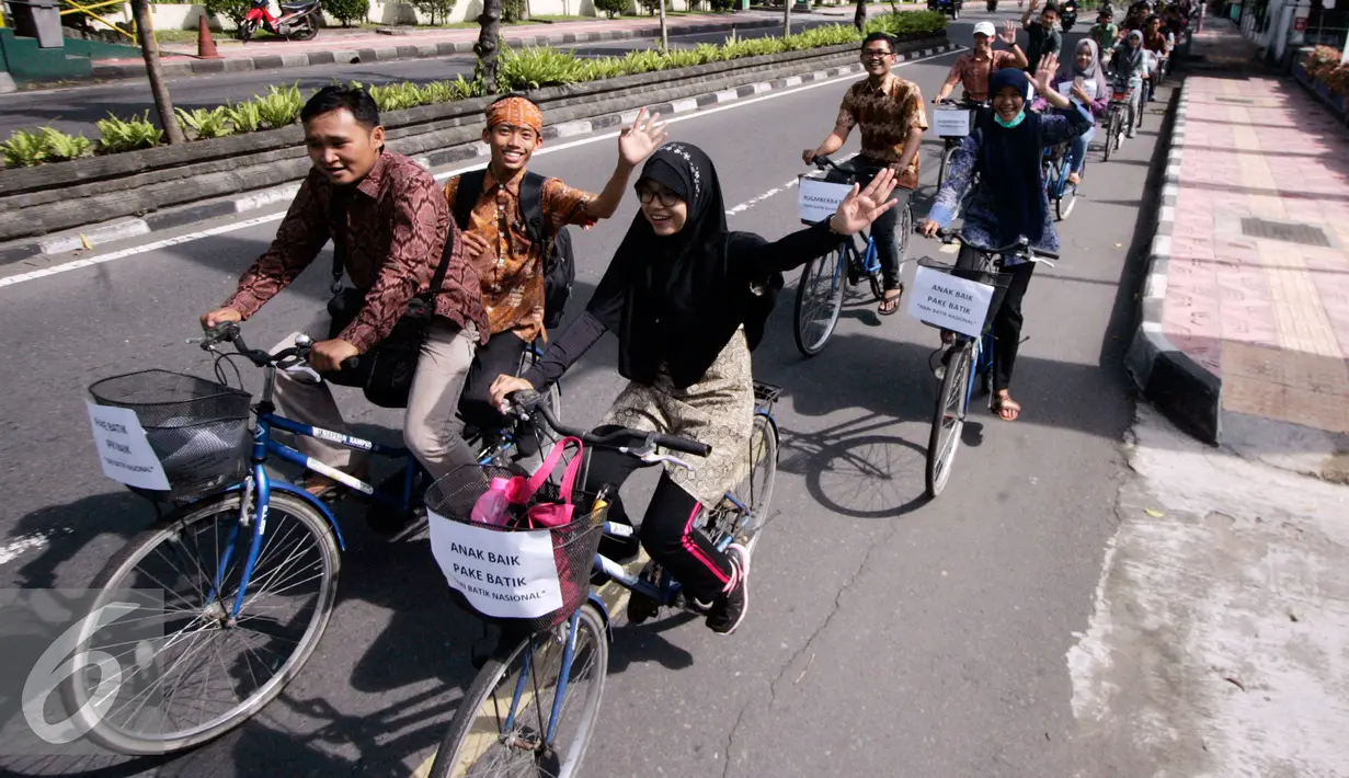 Sejumlah mahasiswa UGM berbusana batik saat pawai sepeda di kawasan Kridosono Yogyakarta, Minggu (2/10). Kegiatan tersebut untuk memperingati Hari Batik Nasional. (Liputan6.com/Boy Harjanto)