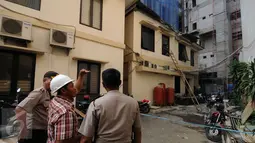 Salah satu pekerja bangunan memberikan keterangan kepadapolisi pasca material bangunan pembangunan gedung Kemenhan jatuh menimpa gedung Ortala Kemenkopolhukam, Jakarta, Senin (30/11/2015). Empat staff menderita luka. (Liputan6.com/Helmi Fithriansyah)