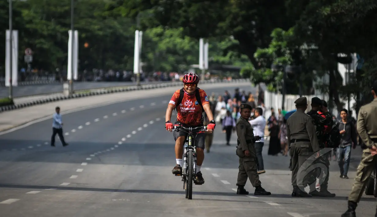 Seorang warga menggunakan sepeda untuk menuju kantornya di kawasan Bundaran HI, Jakarta, Rabu (22/4/2015). Sejumlah jalan utama di Jakarta ditutup total untuk sementara waktu terkait puncak Konferensi Asia-Afrika (KAA). (Liputan6.com/Faizal Fanani)