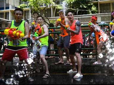 Sejumlah orang bersuka cita menggunakan pistol air saat perang air selama Festival Songkran di Silom Road, Bangkok, Jumat (13/4). Songkran dikenal sebagai festival air yang menandai dimulainya tahun baru tradisional Thailand. (LILLIAN SUWANRUMPHA/AFP)