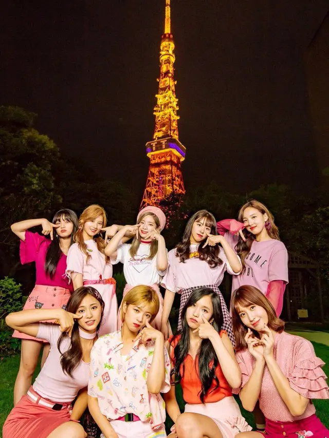 TWICE Saat Berfoto Bersama di Depan Tokyo Tower yang Menampilkan Judul Lagu TT di Layarnya
