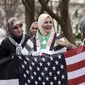 Warga Muslim berkumpul menggelar aksi protes di depan Gedung Putih, Washington DC, AS, Jumat (8/12). Beberapa dari mereka mengenakan syal keffiyeh khas Palestina atau memakai warna-warna yang menyimbolkan bendera Palestina. (Eric BARADAT / AFP)