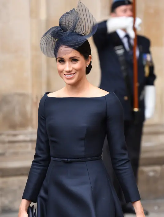 Duchess of Sussex, Meghan Markle tersenyum saat tiba menghadiri kebaktian di Westminster Abbey, London, (10/7). Kebaktian ini digelar untuk memperingati 100 tahun Angkatan Udara Kerajaan Inggris. (AFP Photo/Chris J Ratcliffe)