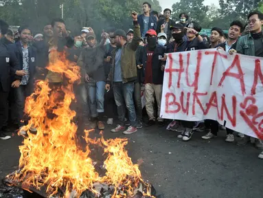 Mahasiswa gabungan se-Jabodetabek membakar ban bekas saat unjuk rasa di depan Istana Merdeka, Jakarta, Selasa (16/7/2019).  Mereka mengecam pemerintah Jokowi atas hutang negara yang melonjak, politik dagang sapi, diskon pajak 300 persen, dan krisis penegakan HAM. (merdeka.com/Iqbal S. Nugroho)