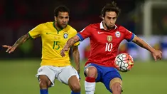 Gelandang Chile, Jorge Valdivia (kanan) berusaha mengontrol bola dari kejaran bek Brasil, Dani Alves pada kualifikasi Piala Dunia 2018 di Santiago, Chile (8/10/2015). Chile menang atas Brasil dengan skor 2-0. (AFP PHOTO/MARTIN BERNETTI)