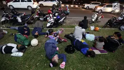 Pemudik menyempatkan beristirahat di pinggir jalan Kota Cirebon karena kelelahan berkendara dari Jakarta, Jumat (24/6). (Liputan6/JohanTallo)