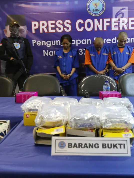 Petugas menunjukkan barang bukti ekstasi asal Jerman berserta ketiga tersangka saat rilis di Jakarta, Senin (4/3). Ketiga tersangka yang dibekuk berinisial E, D dan M. (Liputan6.com/Angga Yuniar)