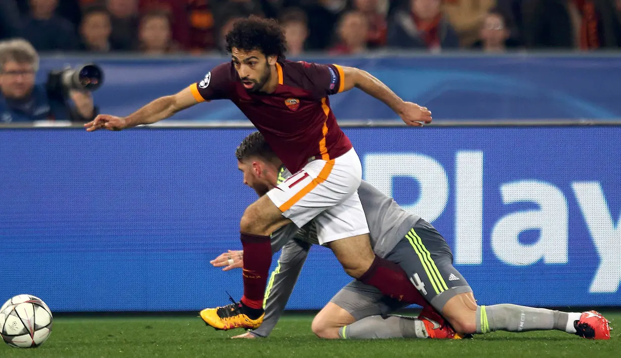 Penyerang AS Roma, Mohamed Salah (kiri) berusaha melewati bek tangguh Real Madrid, Sergio Ramos pada leg pertama 16 besar Liga Champions di Stadion Olimpico, Italia (18/2). Real Madrid menang atas AS Roma dengan skor 2-0. (REUTERS/Alessandro Bianchi)