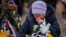 Maria Kurbet, 77 tahun, menangis di makam putranya, seorang prajurit militer yang gugur di Bakhmut, saat upacara peringatan satu tahun dimulainya perang Rusia-Ukraina, di sebuah pemakaman di Bucha, Ukraina, Jumat, 24 Februari 2023. (AP Photo/Emilio Morenatti)
