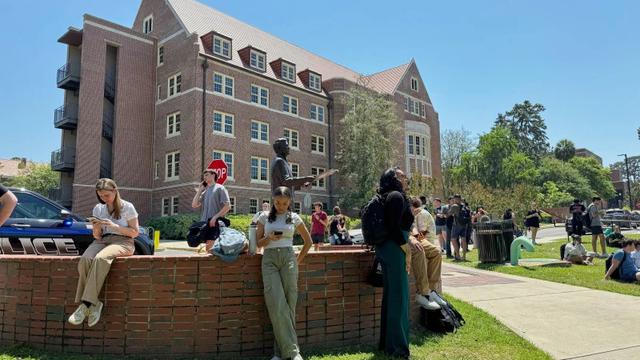 Mahasiswa di lokasi penembakan di Florida State University (FSU) atau Universitas Negeri Florida pada Kamis (1/4/2025) menunggu kabar ada penembak aktif. (AP/Kate Payne)